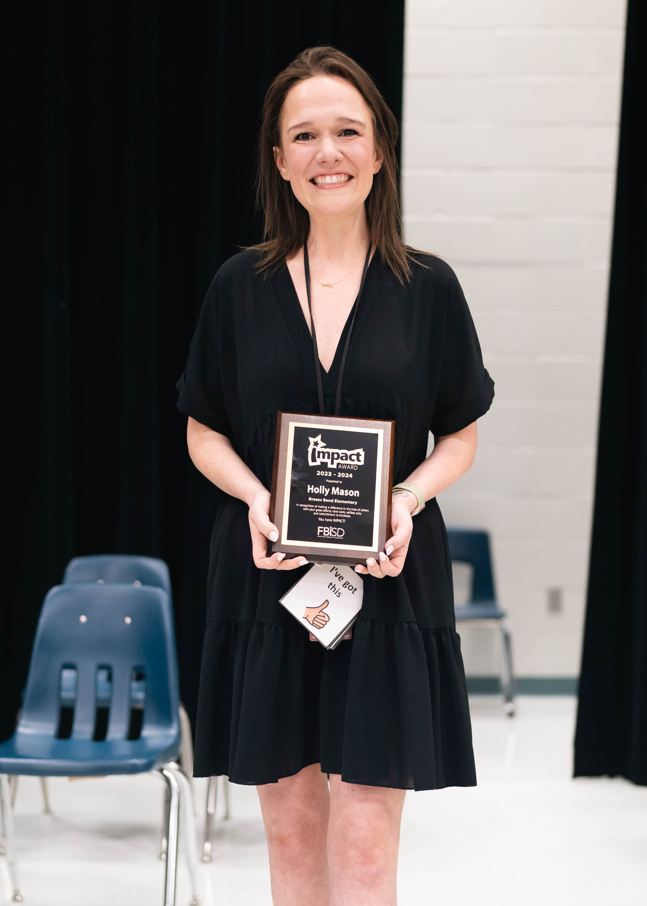 Holly Mason holding the Impact Award plaque